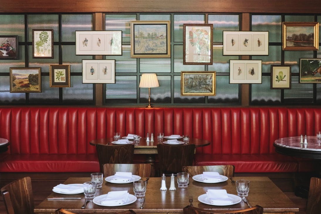 Red booth seating, with photos on back wall of restaurant.